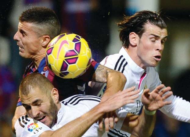 مهاجما ريال مدريد كريم بنزيمة وغاريث بيل في صراع على الكرة مع مدافع ايبار ابراهام مينيرو رويترز