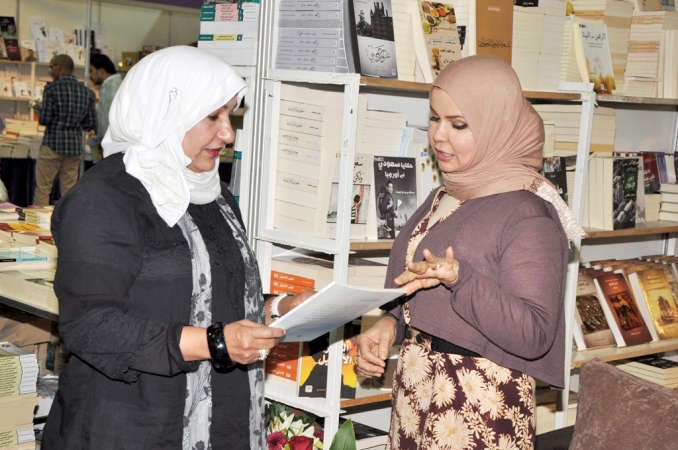 الزميلة عواطف العلوي متحدثة الى الزميلة زينب ابوسيدو في المعرض﻿