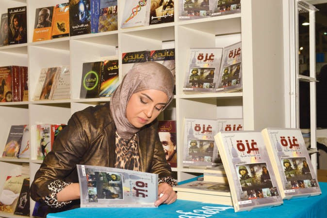 البغدادي خلال توقيع كتابها غزة بين الجزيرة والعربية﻿