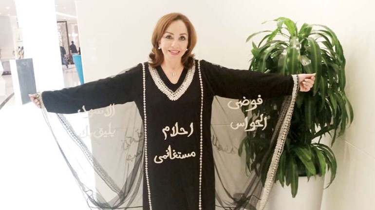 وترتدي ثوبا كويتيا يحمل اسمها واسماء رواياتها