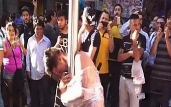 صورة: تعرية لص وربطه بعامود إنارة لمحاولته سلب عجوز