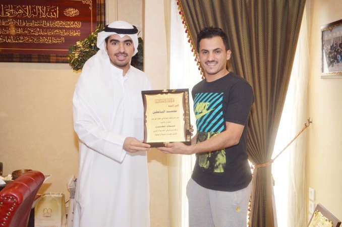 نواف المطيري يسلم درعا تذكارية الى محمد البابطين﻿