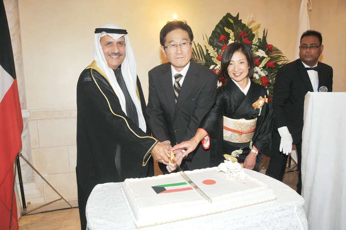 السفير محمد الرومي مشاركا السفير الياباني توشيهيرو تسوجيهارا وحرمه قطع كيكة الاحتفال﻿