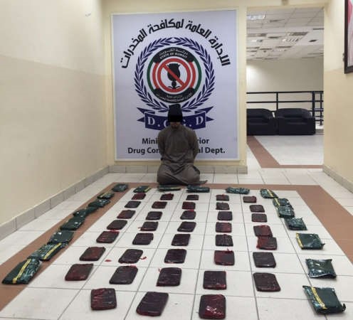 المتهم وامامه كمية الحشيش المضبوطة﻿