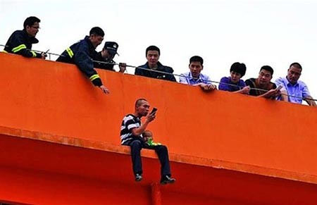 بالصور.. صيني يهدد بالقفز من مبنى مع ولديه بعدما هجرته زوجته