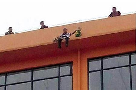 بالصور.. صيني يهدد بالقفز من مبنى مع ولديه بعدما هجرته زوجته
