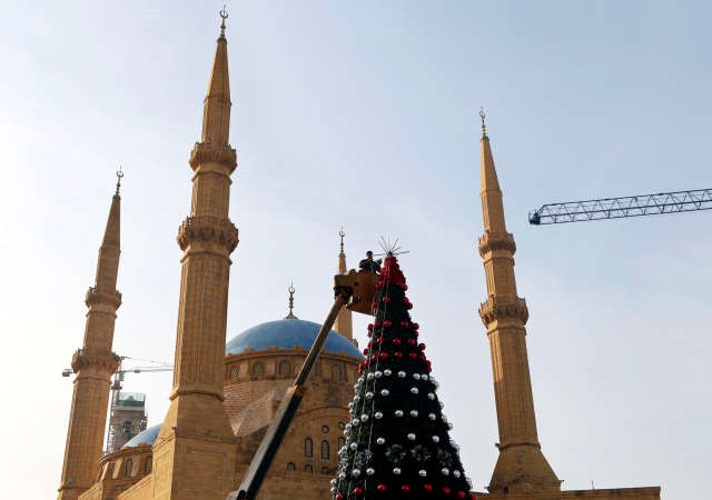 استعدادات على قدم وساق لاستقبال اعياد الميلاد وراس السنةفي الصورة عامل يزين شجرة العيد في وسط مدينة داون تاوناب ﻿