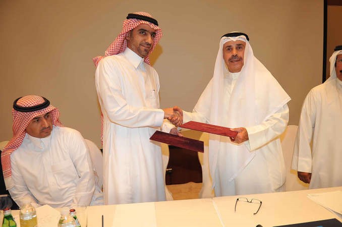 بدر المطر ودهشام الفالح يتبادلان نسختي الاتفاقية اسامة ابوعطية