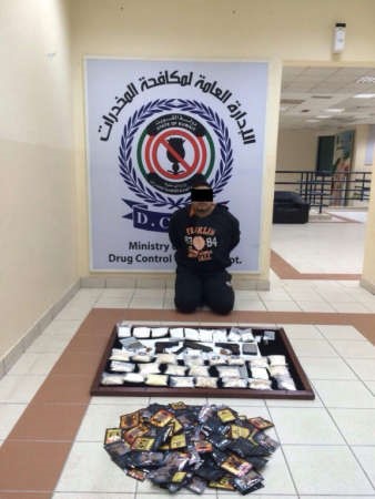 احد المتهمين الثلاثة امام المخدرات المضبوطة 
