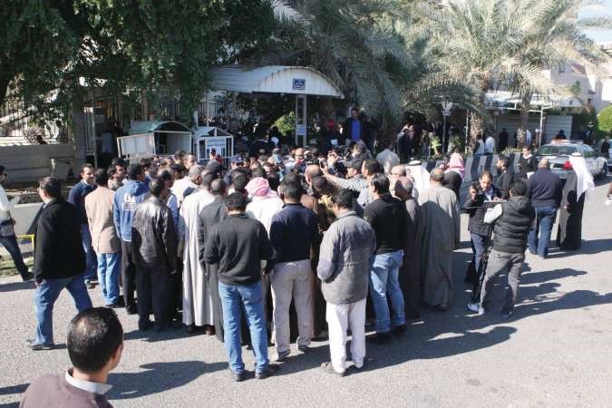 احد رجال الامن يحاول تهدئة المحتجين المصريينامام القنصلية
