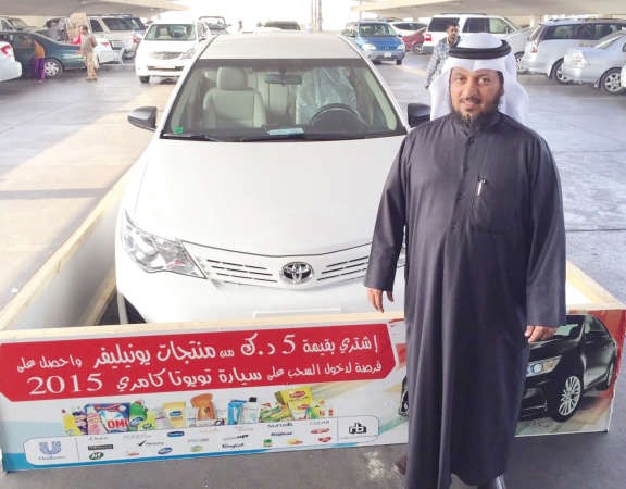 مشعل الجلال إلى جانب السيارة المقدمة من شركة البحر