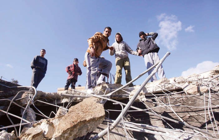 ﻿فلسطينيون يتفقدون احد المباني التي هدمها الاحتلال بالخليل في الضفة امس الاول	رويترز ﻿