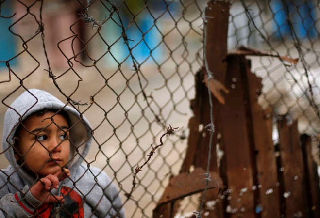 طفل فلسطيني يلقي نظرة امس على اطلال منزل عائلتهالذي هدمه القصف الاسرائيلي خلال الحرب الاخيرة على غزة رويترز 