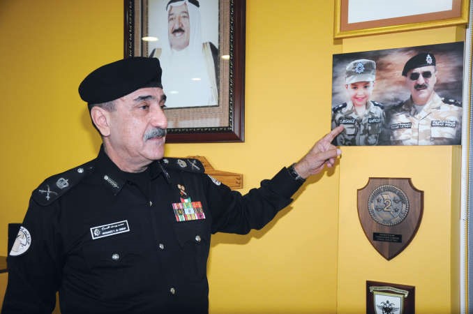 الشيخ محمد اليوسف يشير الى صورة حفيده محمد