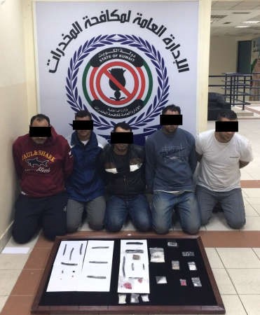 المتهمون الخمسة وامامهم المضبوطات 