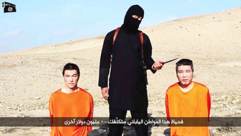 صورة من الفيديو الذي نشره داعش للرهينتين اليابانيين ومعهما عنصر ملثم من التنظيم سيانان﻿
