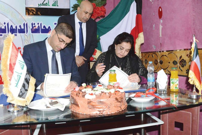 الشيخة ايمان الصباح خلال توقيع العقد مع محافظ الديوانية عمار المدني ﻿