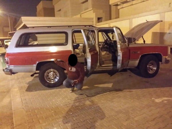 المتهم امام مركبته التي فر بها من رجال امن الجهراء 
