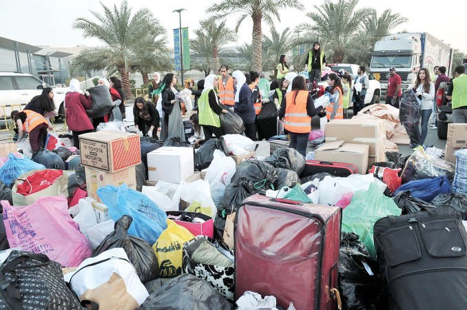 متبرعون ومتطوعون خلال تجهيز المساعدات اثناء الحملة ﻿