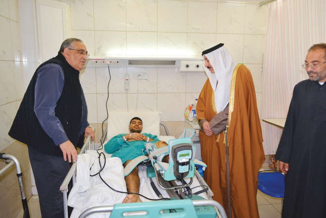 الفريق متقاعد فهد الامير خلال زيارته لاحد البحرينيين المصابين 