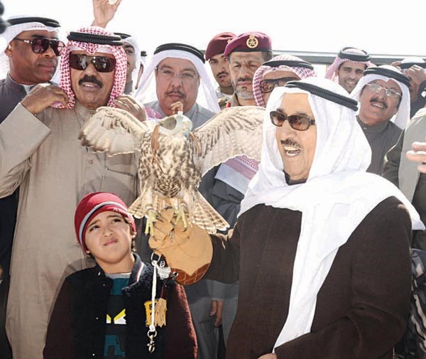 صاحب السمو الامير الشيخ صباح الاحمد يحمل صقرا ويبدو سمو ولي العهد الشيخ نواف الاحمد وعدد من الحضور