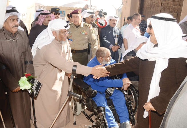 سمو الامير الشيخ صباح الاحمد مصافحا احد رواد القرية