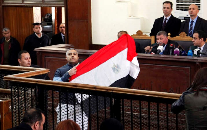 الصحافي محمد فهمي يرفع العلم المصري اثناء المحاكمة امسرويترز