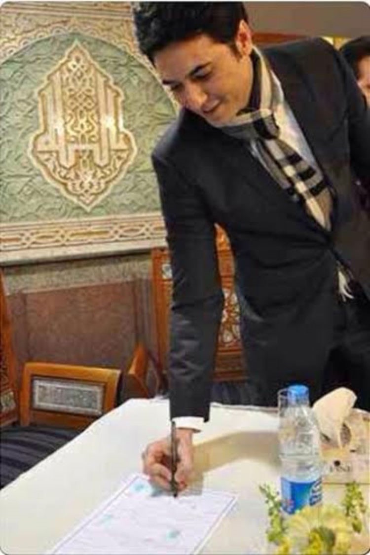 صورة احمد عز وهو يوقع على الورقة