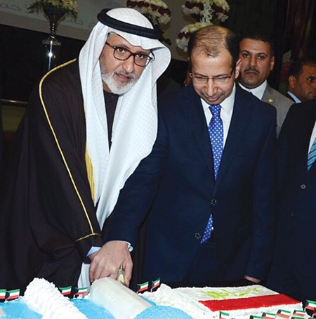 د سليم الجبوري يشارك السفير غسان الزواوي قطع كعكة الحفل 