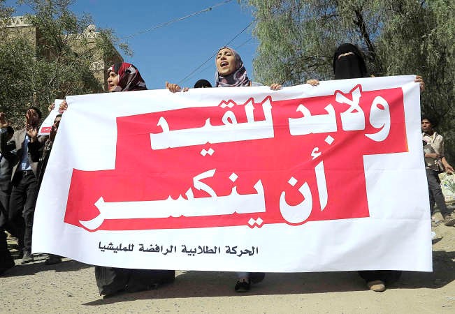 طالبة يمنية ترفع لافتة منددة بالانقلاب الحوثي خلال تظاهرة في جامعة صنعاء امس رويترز 
