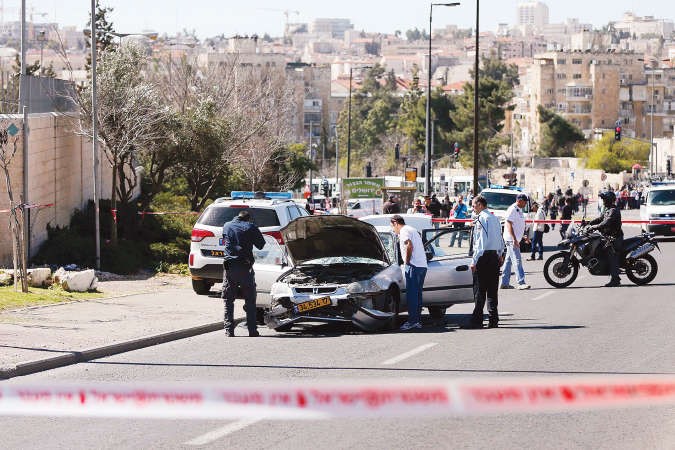 الشرطة الاسرائيلية خلال تفحص السيارة التي استخدمها فلسطيني في عملية الدهس بالقدس امسرويترز ﻿