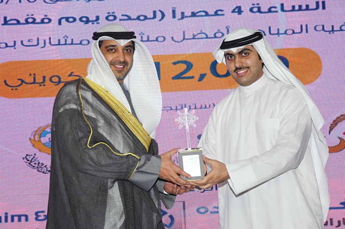 الشيخ محمد العبدالله يتسلم درعا تذكارية من عبدالله الغانم﻿