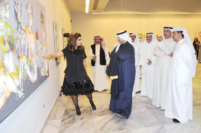 شيماء اشكناني تشرح فكرة لوحاتها للشيخ صباح جابر المبارك ويبدو معلي اليوحة ووليد الخشتي ومجموعة من الحضور