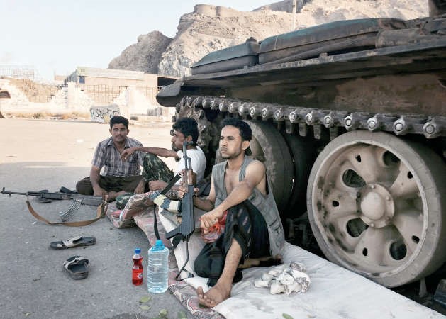 مسلحون من اللجان الشعبية الموالية للرئيس عبد ربه منصور هادي يمضغون القات خلال حراستهم لعدد من المواقع في عدن	اپ﻿