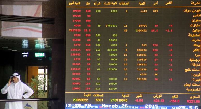 مستثمر يجري اتصالا في قاعة البورصة في وقت تظهر الشاشة عمليات البيع والشراء الكبيرة المنفذة يوم الخميس الماضي عندما انهارت البورصة الكويتية على وقع عمليات عاصفة الحزمافپ﻿