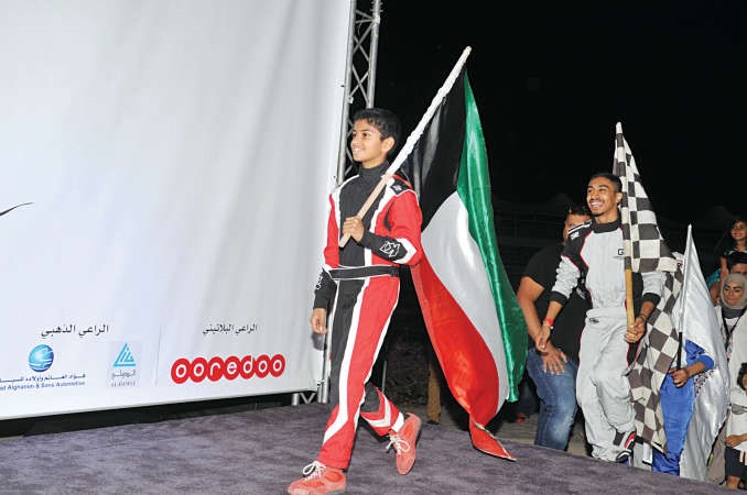 السائق البطل الخالد حاملا العلم