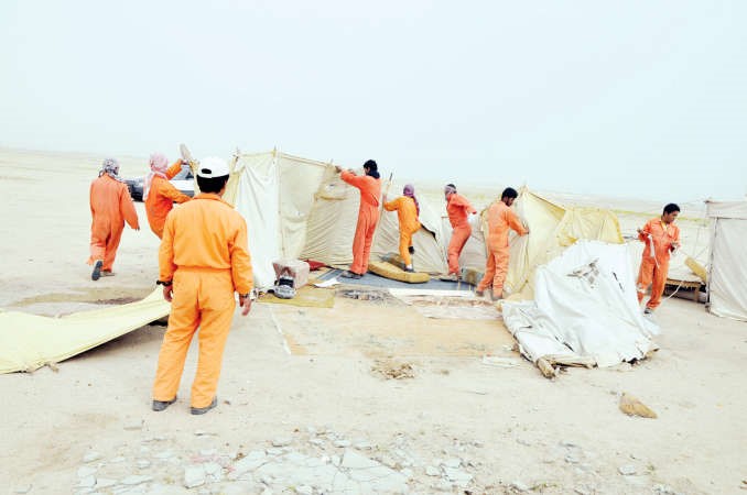 عمال البلدية يفككون احدى الخيام وفي الاطار جرافة تزيل غرفة كيربي احمد علي