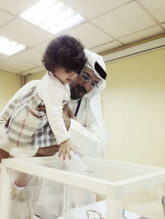 علي العنزي يدلي بصوته مع طفلة من جيل المستقبل