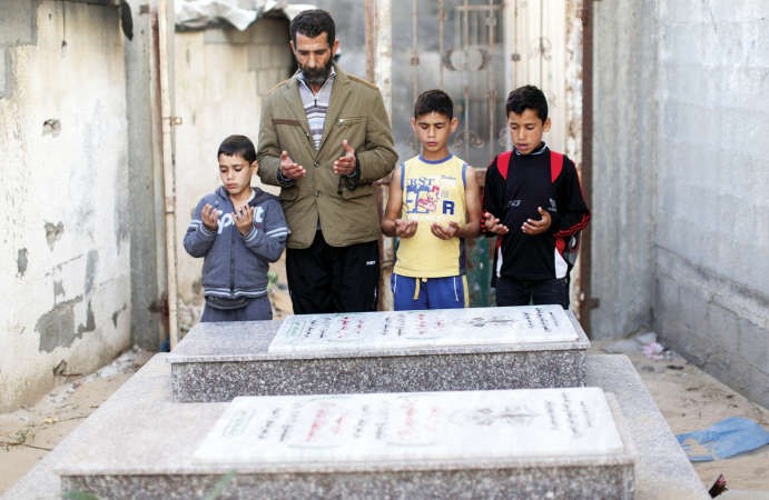 عائلة فلسطينية خلال زيارة مقبرة اقاربقضوا خلال الحرب الاسرائيلية الاخيرة على غزة امس 	افپ ﻿
