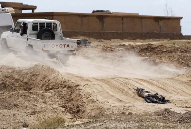 سيارة تابعة للحشد الشعبي تجر جثة احد مقاتلي داعش في تكريت رويترز