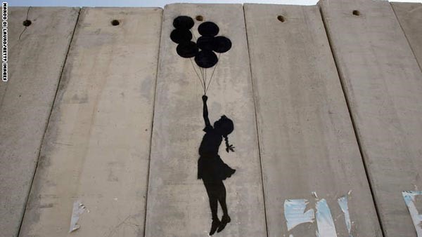 الفتاة مع بالوناتها على جدار الفصل في رام الله