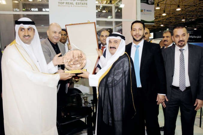 الشيخ نمر الصباح يتلقى هدية تذكارية من الشيخ مالك الصباح ووليد القدومي عقب افتتاح المعرض 