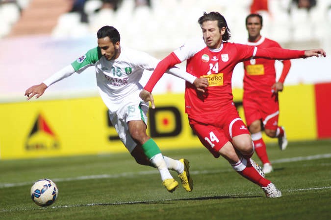 لاعب الاهلي صالح الجمعان يحاول التخلص من مضايقة مدافع تراكتور اندرانيك تيموريان افپ﻿