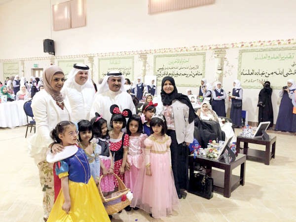 د سعود الحربي وبدرية الخالدي يتوسطان الطلبة المشاركين في المعرض ﻿