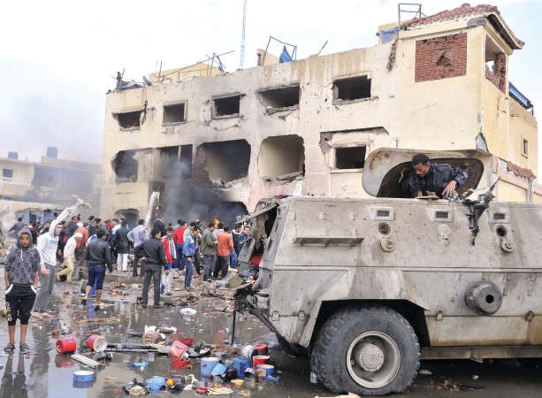 مواطنون مصريون يتفقدون موقع قسم الشرطة بالعريش الذي استهدفه التفجير الانتحاري امسافپ
