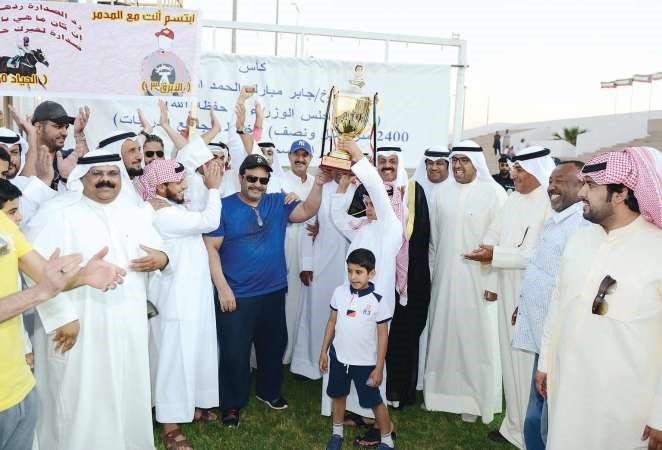 ممثل سمو رئيس الوزراء محافظ حولي الشيخ نواف الاحمد يسلم الكاس الى الفائز والى جانبه الشيخ ضاري الفهد