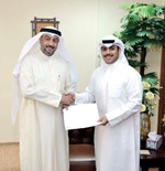 زيد العازمي يصافح محمد السعدي خلال تقديم الدعم المالي