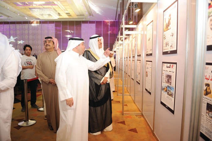 الزميل يوسف خالد المرزوق يقدم شرحا للوزير الشيخ سلمان الحمود عن بعض الصور التي تحمل مانشيتات من تاريخ الانباء