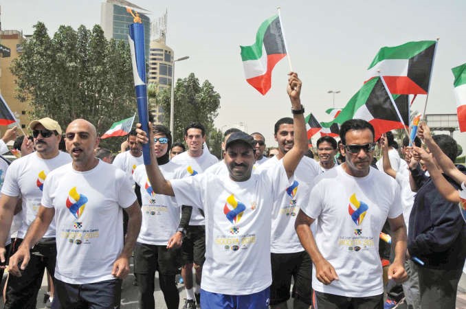 الفنان طارق العلي حاملا الشعلة 