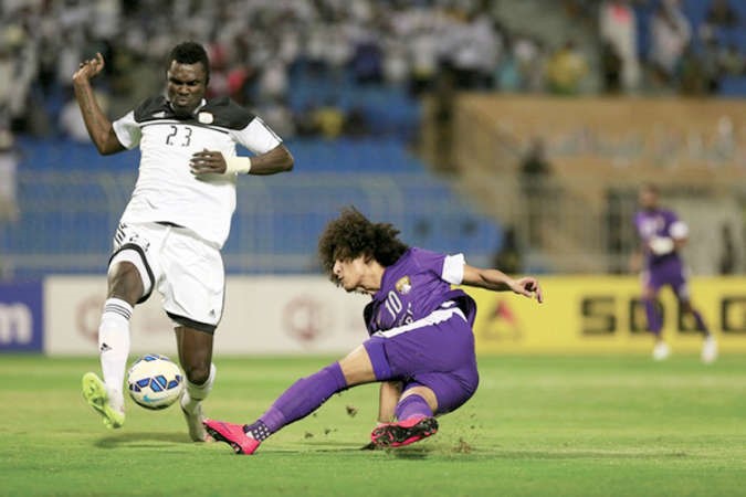 لاعب العين عمر عبدالرحمن يمرر الكرة وسط ملاحقة مدافع الشباب محمد اوال